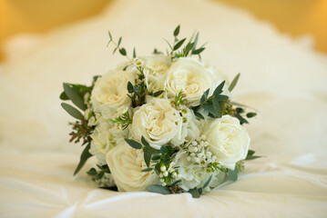 Beautiful bunch of white roses bouquet on white bed