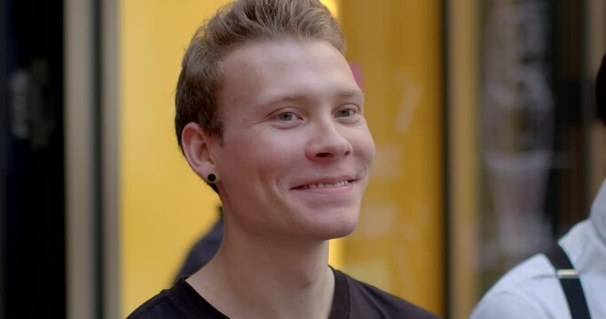 Portrait of young man embarrassed student outdoors. Person smiling close-up face. Each person is unique, their visual depiction should reflect distinctiveness. Happy smile anticipation of pleasure.