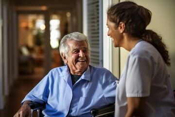 Elderly man in wheelchair conversing with cheerful nurse