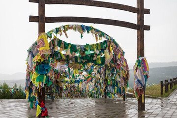 The gate with hii-morin on the territory of the Buddhist Datsan Rinpoche Bagsha on Mount Lysaya, Ulan-Ude, Buryatia, Russia. Colorful Buddhist Prayer Flags with Mantras
