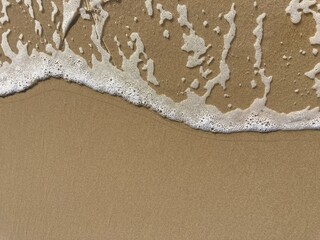 a foamy wave on the sand of the north sea beach