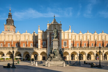Statue of Adam Mickiewicz and Sukiennice buidning in Cracow, Poland - obrazy, fototapety, plakaty