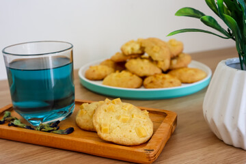 Homemade cheese baked cookies served with Telang (Clitoria ternatea) tea or herbal drink on the wooden table