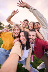 Vertical group young cheerful multi-ethnic friends taking selfie mobile phone outdoor. Happy people...