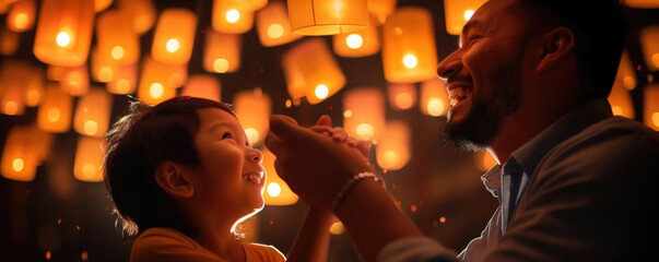 An Asian father and son highfive each other as they hold the lucky lantern during a lantern festival in Taiwan.