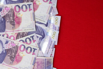 top view. 100 GEL. Georgian lari on a red textile background. Cash of Georgia. Tbilisi. Money for shopping. Concept of wealth, power of money, immigration, travel, tourism, citizenship, salary, debt
