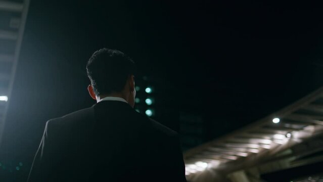 Calm employee admiring evening architecture back view. Man going to dark airport