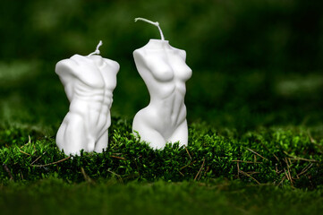 Białe naturalne eko świeczki w kształcie kobiety i mężczyzny w lesie na mchu