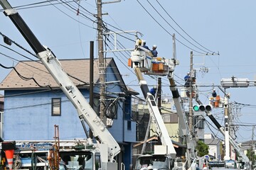 Fototapeta premium A view of the overhead line work of electric poles along the road. 