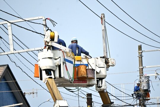 A view of the overhead line work of electric poles along the road.
