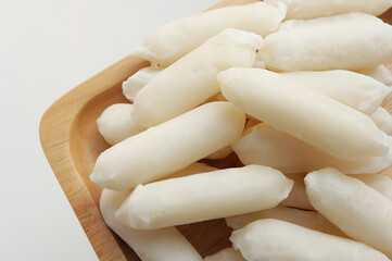 Korean food, Rice cake stick  on wooden plate. (steamed rice cakes) Korean rice cake with cheese inside, specifically the kind used in tteokbokki.