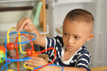 Boy playing with developmental toys on table at home