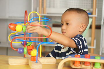 Boy playing with developmental toys on table at home