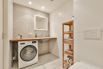 a small laundry room with a washer and dryer in the corner, there is a wooden shelf on the wall