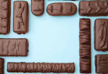 Different tasty chocolate bars on light blue background, flat lay. Space for text