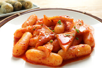 Korean food, Rice cake stick in a spicy gochujang sauce and fish cakes. Tteokbokki and Fried seaweed rolls or Gimmari on white background. Korean Stir-fried Rice Cake
