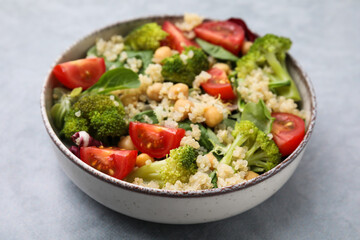 Healthy meal. Tasty salad with quinoa, chickpeas and vegetables on grey table, closeup