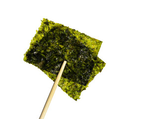 Crispy nori seaweed on white background with clipping path. Chopsticks hold a piece of crispy dried seaweed isolated on white background. Dry seaweed sheets. 