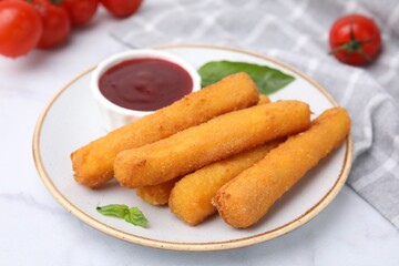 Tasty fried mozzarella sticks served with tomato sauce on white marble table