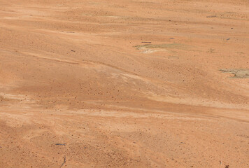 Beach sand, beautiful dark background. Desert landscape with red ground.