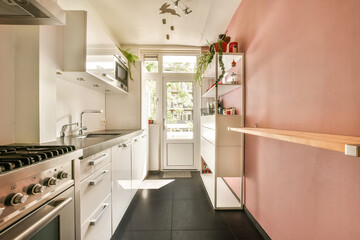 a kitchen area with pink walls and white appliances on the stoves, sink and dishwasher in the corner