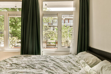 a bedroom with a bed, window and plants in the corners on the right side of the room to the left