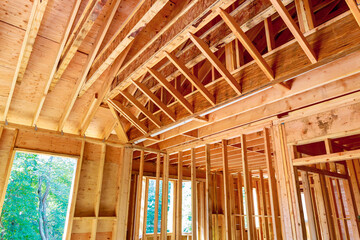 New house interior view unfinished construction with wooden framing beams
