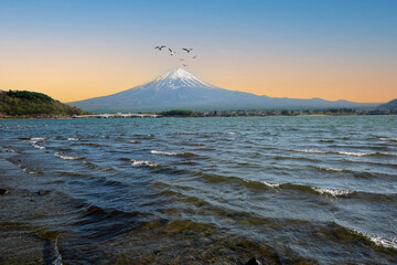 kawaguchiko, Japan - August 23,2023: Fishermen fishing in lake with Fuji mountain in the background.