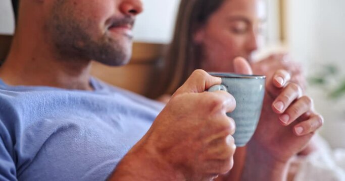 Love, coffee and couple relaxing in bed for bonding together o a weekend morning in apartment. Calm, happy and young man and woman drinking a mug of latte in the bedroom of a modern home in Australia