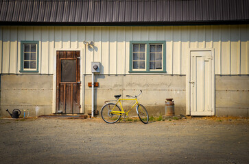 Fototapeta na wymiar Yellow Bicycle in Front of Farm Building