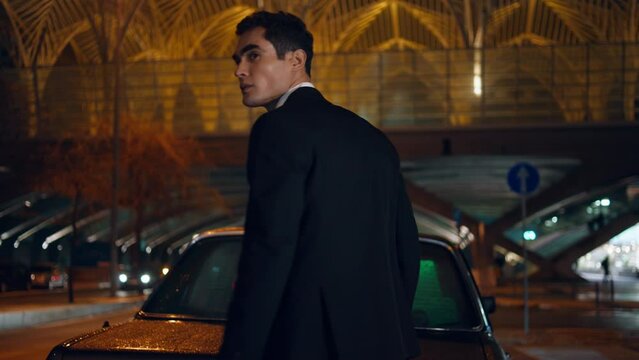 Man traveler taking suitcase car trunk at evening. Employee preparing for trip