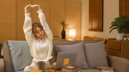 Home lifestyle concept, Young woman stretching to relaxation after work hard in late night winter