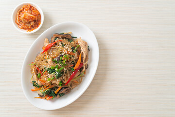 japchae or stir-fried Korean vermicelli noodles with vegetables and pork topped with white sesame