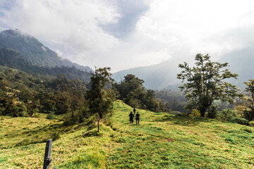 Fototapeta na wymiar young hiker walking through a rural area on a cloudy day on the slopes of the Turrialba Volcano