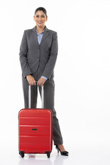 Full length of confident female professional manager with suitcase and standing against white background.