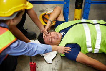 senior worker fell over and his head is bleeding on the floor in the factory