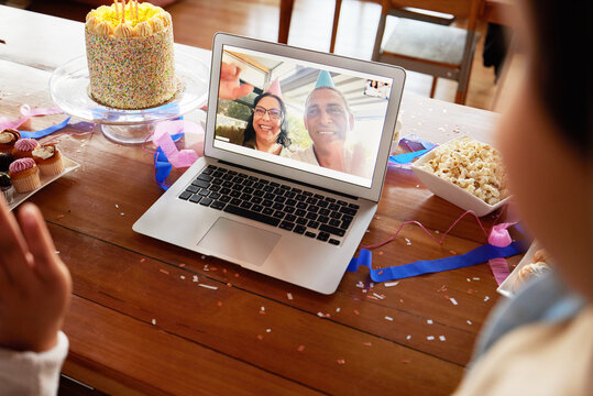 Birthday cake, video call and laptop on table with people online to celebrate on virtual chat. Couple talking to family with internet connection, communication and technology at home for celebration
