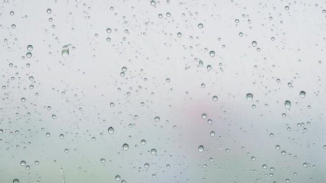 Slow motion background of raindrop sliding on window glass