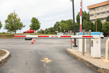parking lot gate, a barrier depicting control, access restriction, transition, and urban confinement