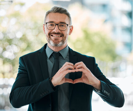Portrait, business man and heart hands outdoor for care, kindness or love emoji for peace. Happy mature executive entrepreneur with finger shape for thank you, trust and like icon for support in city - Powered by Adobe