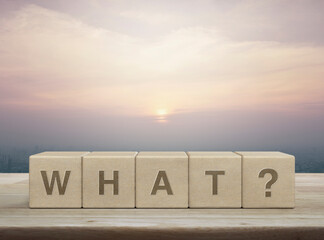 What letter on wood block cubes on wooden table over city tower and skyscraper at sunset, vintage style, Business communication concept