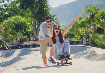 Young happy couple with skateboards enjoy longboarding at the skatepark © romaset