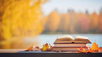 Books on autumn orange, yellow, purple leaves and blurry landscape and cloudy blue sky in...
