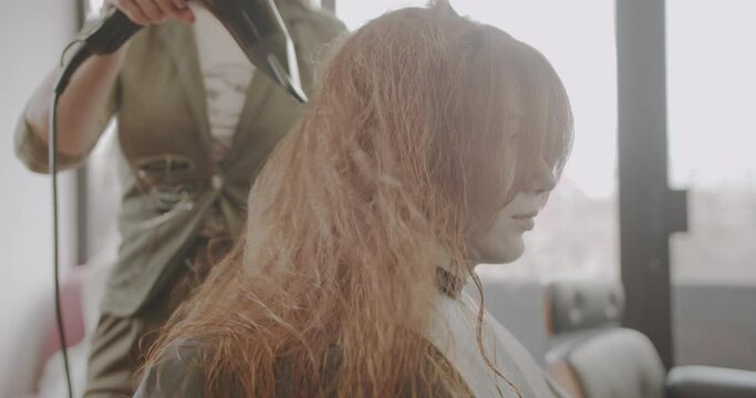 Hair drying of ginger girl, trucking motion