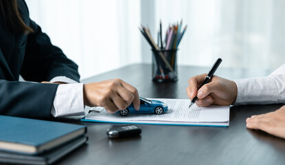 Closeup asian women people car saler or sales manager offers to sell a car and explains and reads the terms of signing a car contract and insurance.