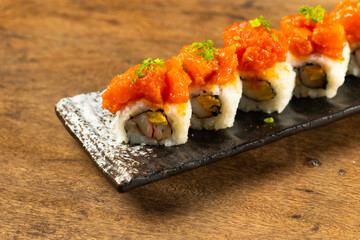 sushi with chopsticks close up. Assorted japanese sushi food. sushi with tuna, crab, salmon, eel and rolls. Japanese food isolated on wood background