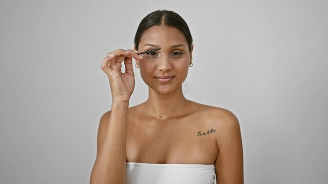 Young latin woman smiling confident combing eyebrows with brush over isolated white background