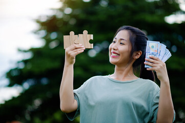 Dollar in the hands of an Asian woman Savings, Investments, Salary, Income, Cash Flow, Happiness and Financial Success and Investments.