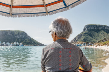 Fototapeta premium Reflections by the Shore: Aging Individual's Ocean Retreat