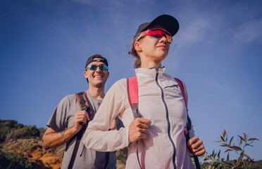 Happy young couple climbs to the top in the mountains near the ocean